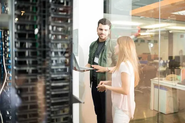 Engineers in a data centre checking the servers behind a monitored business application
