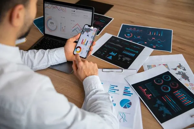 Game analytics dashboards and retention charts reviewed on a phone and printed reports