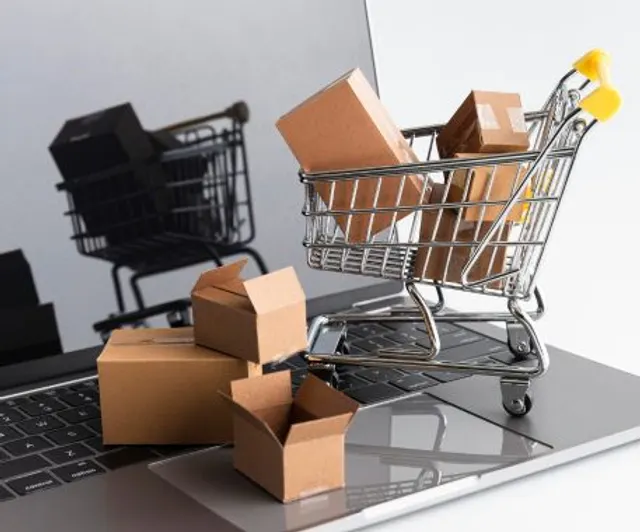 Shopping cart and parcels on a laptop, representing online ticket and merchandise sales