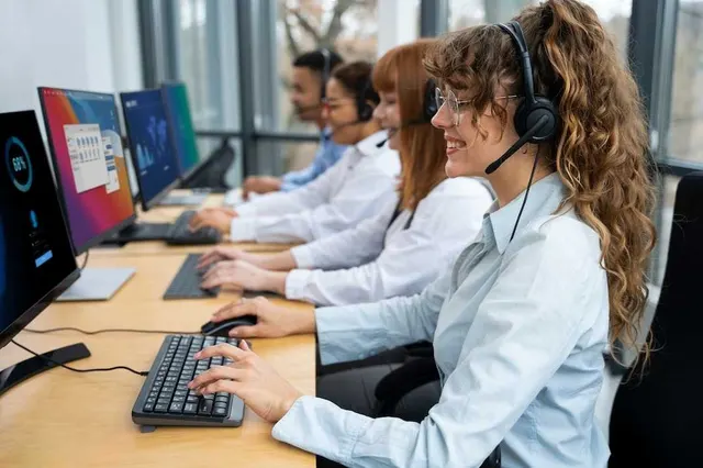 Telecom customer care agents with headsets handling subscriber tickets at their computers