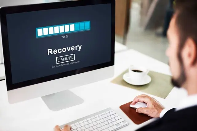 Administrator watching a recovery progress bar while restoring a server backup on a desktop