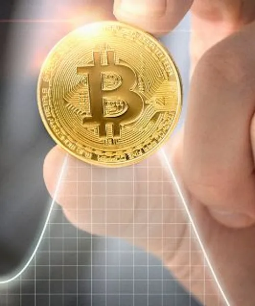 Bitcoin coin held over a rising crypto price chart