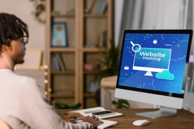 Small business owner checking a website hosting dashboard on a desktop computer at work